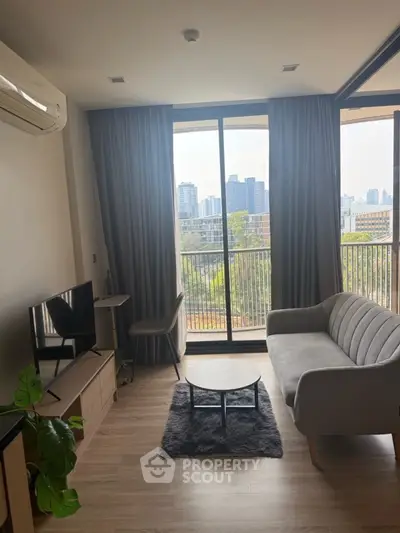 Modern living room with city view, featuring sleek furniture and large windows.