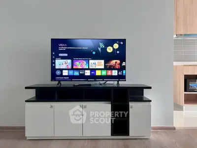 Modern living room with sleek TV stand and flat-screen TV, showcasing contemporary interior design.