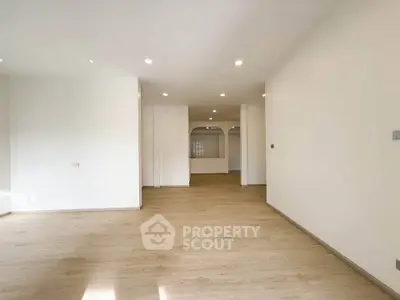 Spacious modern living room with wooden flooring and ample natural light