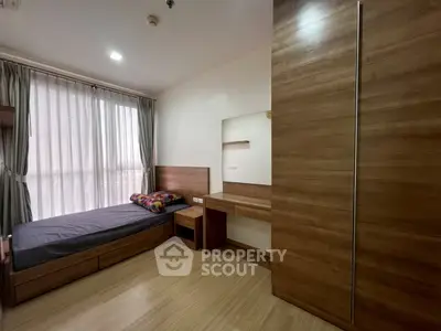 Modern bedroom with wooden furniture and large window for natural light
