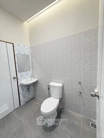 Modern bathroom with sleek tiles and minimalist fixtures in a contemporary real estate property.