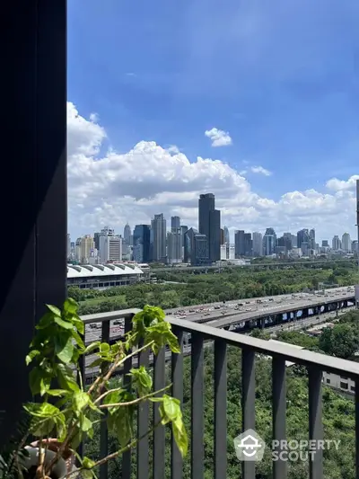 Stunning city skyline view from a modern balcony with lush greenery.