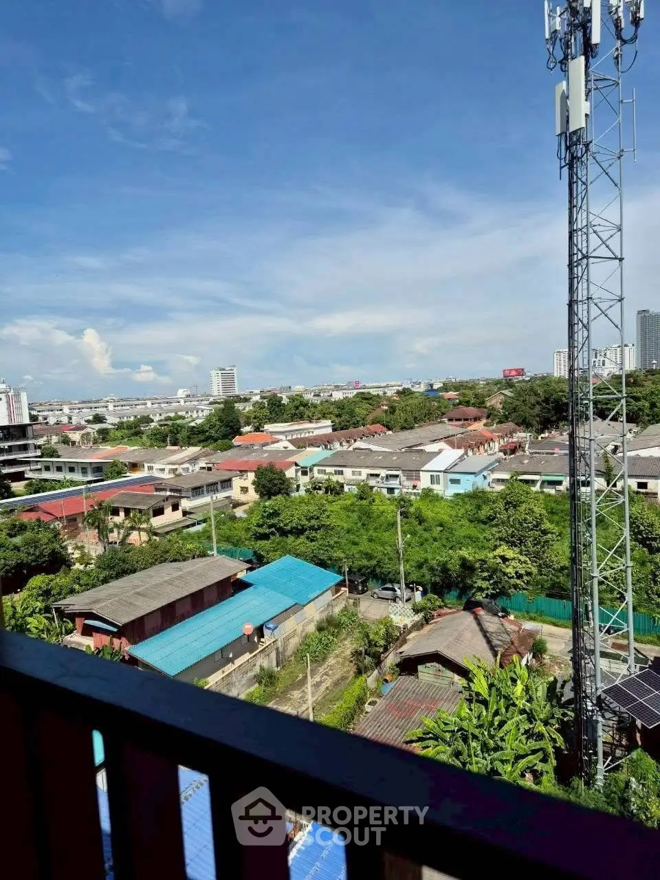 Stunning cityscape view from a high-rise balcony showcasing urban living and greenery.