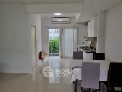 Modern open-layout dining area with sleek kitchen and garden view