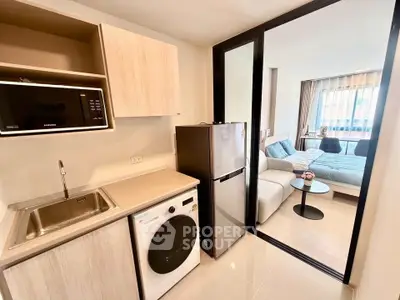 Modern studio apartment with compact kitchen and cozy living area, featuring sleek appliances and stylish decor.