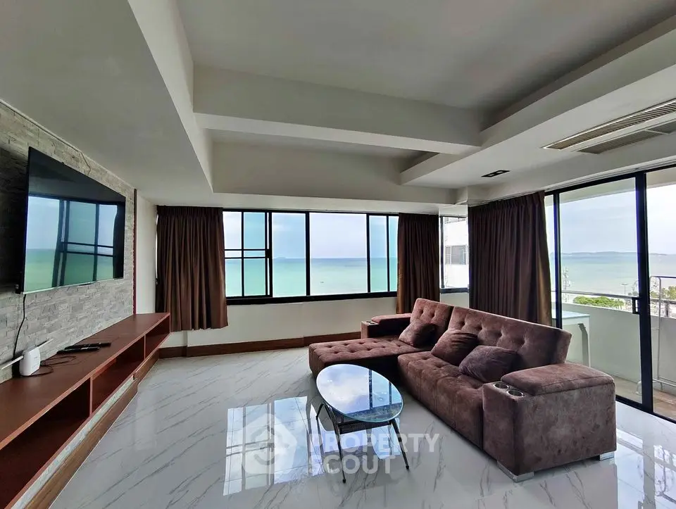 Luxurious beachfront living room with panoramic ocean views and modern furnishings.