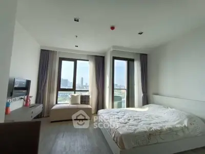 Spacious bedroom with city view and modern decor in high-rise apartment.