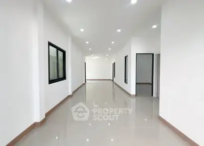 Spacious modern hallway with glossy tiled floors and recessed lighting