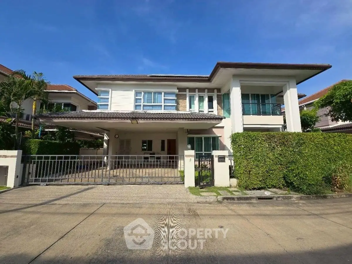 Stunning modern two-story house with spacious driveway and lush greenery.