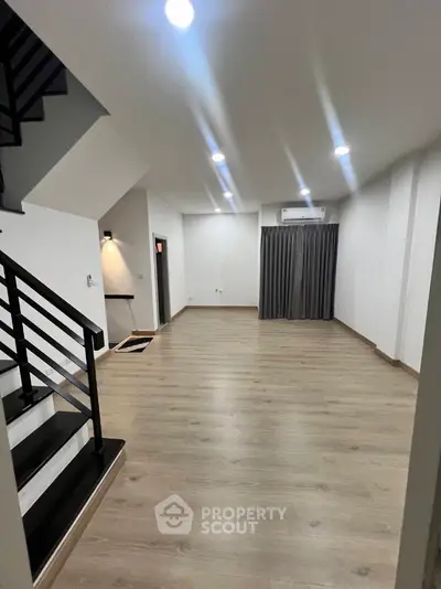 Spacious modern living room with sleek staircase and wooden flooring