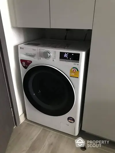 Modern laundry area with high-efficiency washing machine in sleek cabinetry.