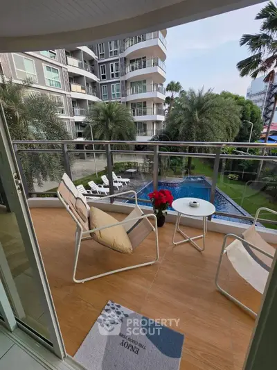 Charming balcony with pool view in modern apartment complex, perfect for relaxation and outdoor enjoyment.