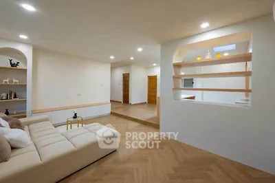 Spacious modern living room with elegant wooden flooring and cozy seating area.