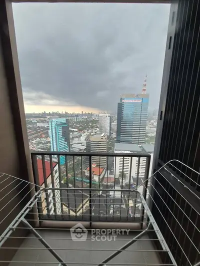 Stunning city view from a high-rise balcony with drying rack, perfect for urban living.