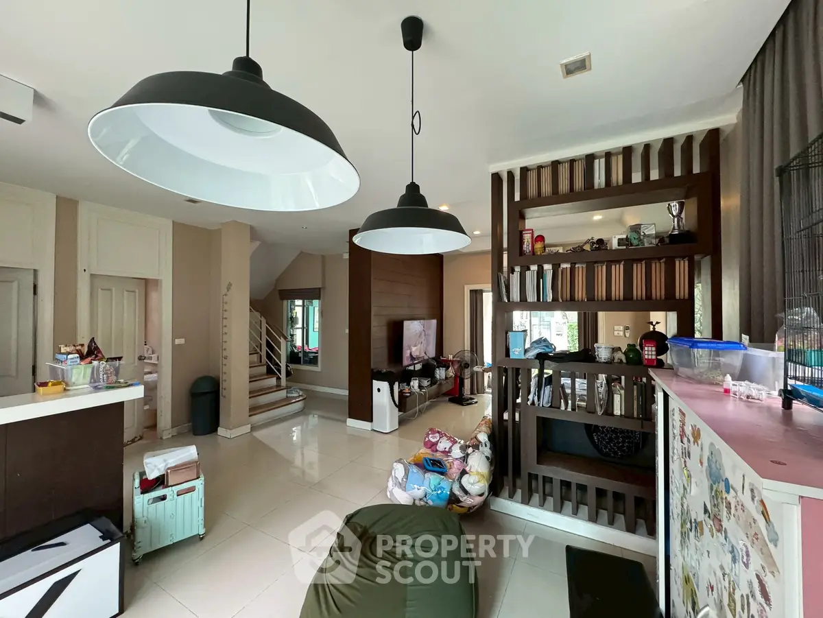 Spacious living room with modern lighting and open layout, ideal for family gatherings.