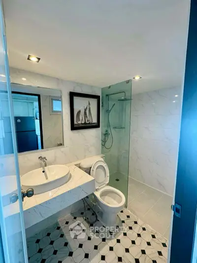 Modern bathroom with glass shower and marble sink in stylish real estate property.