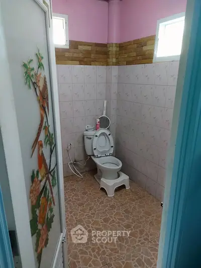 Charming bathroom with unique bird-themed door and tiled walls