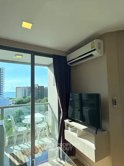 Modern living room with balcony and city view, featuring air conditioning and stylish decor.