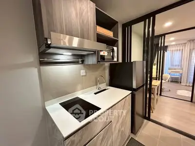 Modern compact kitchen with sleek appliances and open layout in stylish apartment