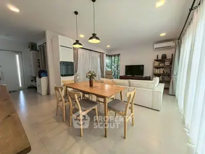 Spacious modern living room with dining area, large windows, and stylish lighting.