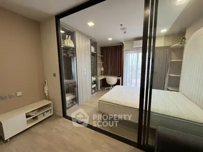 Modern bedroom with glass partition and study area, featuring built-in wardrobe and sleek design.