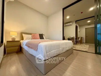 Modern bedroom with cozy decor and warm lighting in a stylish apartment.
