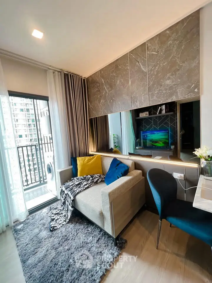 Modern living room with stylish decor and balcony view in a high-rise apartment.