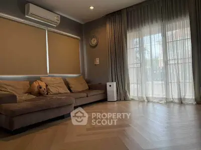 Spacious living room with cozy sofa and large window, perfect for relaxation.