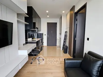 Modern apartment interior with sleek black and white design, featuring a cozy living area and functional workspace.