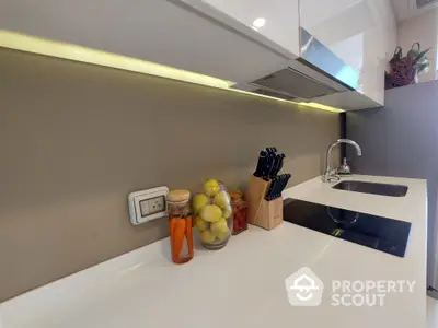 Sleek modern kitchen with under-cabinet lighting accentuating a pristine white countertop, complete with stylish accessories.