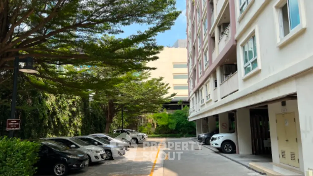 Spacious apartment building with ample parking and lush greenery.