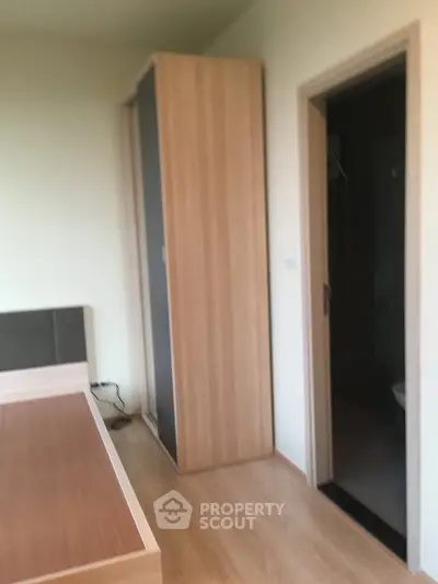 Modern bedroom with wooden flooring and sleek wardrobe design