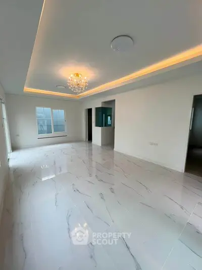 Spacious modern living room with elegant chandelier and marble flooring