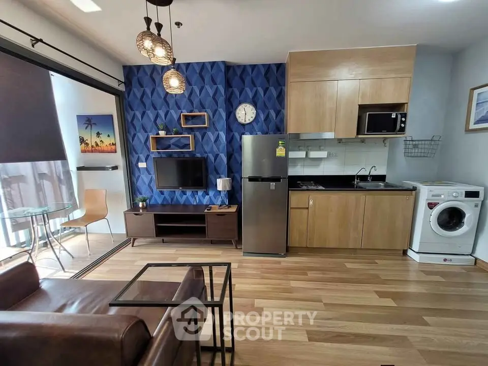 Modern living room with stylish decor, open kitchen, and balcony view in a contemporary apartment.