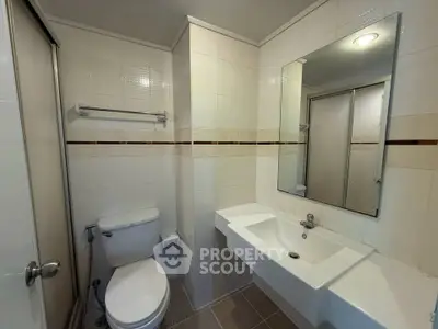 Modern bathroom with sleek fixtures and large mirror in a contemporary apartment.