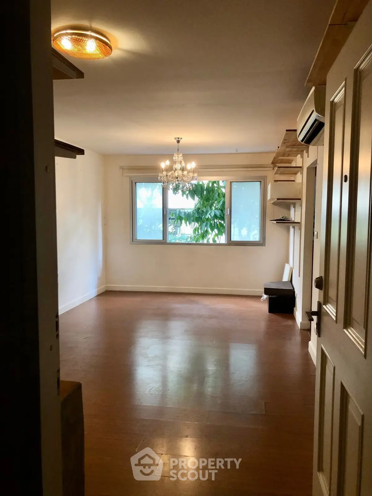 Spacious living room with wooden flooring and large window view