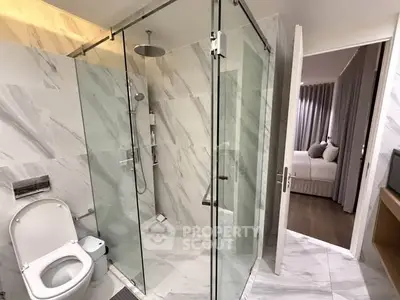 Modern bathroom with glass shower and marble tiles in luxury apartment
