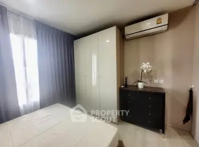 Cozy bedroom with modern wardrobe and air conditioning in a stylish apartment.