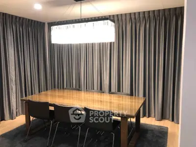 Elegant dining room with modern chandelier and sleek curtains, perfect for stylish entertaining.