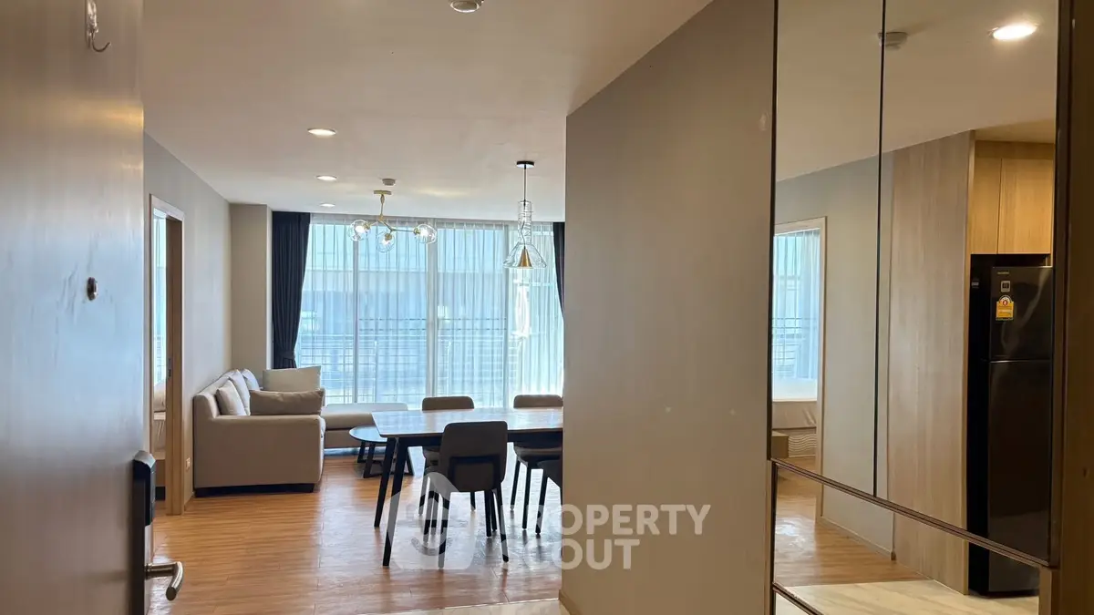 Spacious modern living room with dining area and large windows.