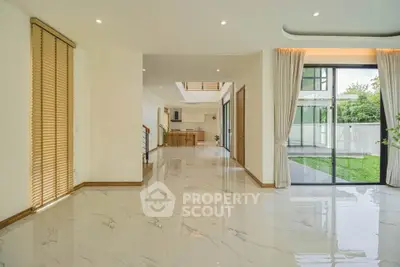 Spacious modern living area with marble floors and garden view