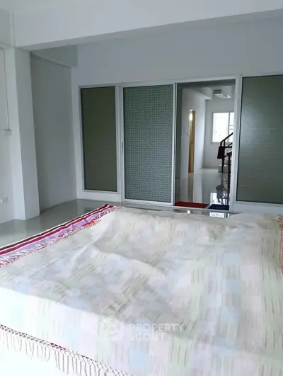 Spacious bedroom with sliding glass doors and natural light