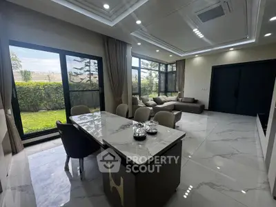 Luxurious modern living room with garden view, marble flooring, and elegant dining area.