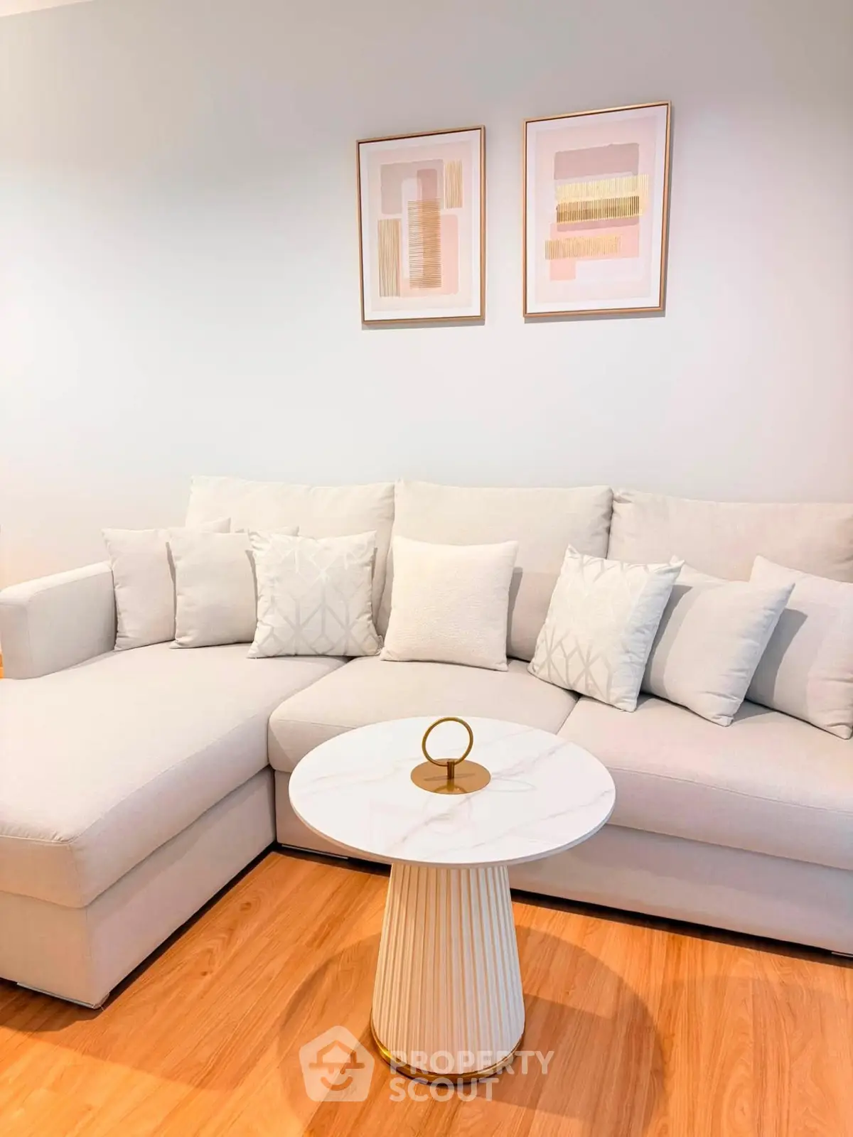 Elegant living room with modern white sofa and stylish coffee table on wooden floor.
