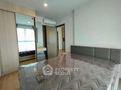 Modern bedroom with sleek design and ample natural light, featuring a stylish bed and built-in wardrobe.