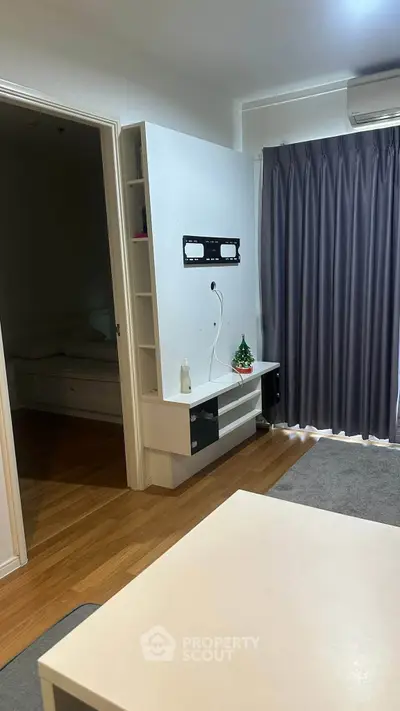 Modern living room with wall mount, hardwood floors, and cozy decor