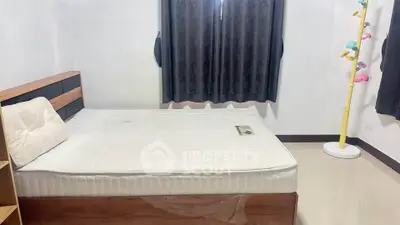 Cozy bedroom with modern decor and ample natural light, perfect for relaxation and comfort.