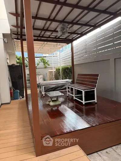 Charming outdoor patio with wooden deck and modern seating, perfect for relaxation and entertaining.