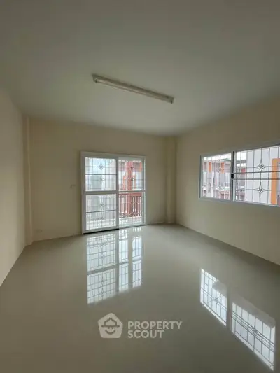 Spacious empty room with large windows and glossy floor, perfect for customization.