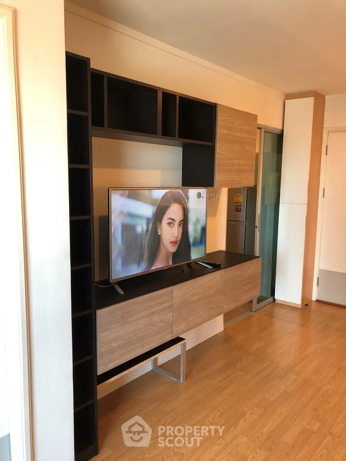 Modern living room with sleek TV unit and wooden flooring, perfect for stylish urban living.